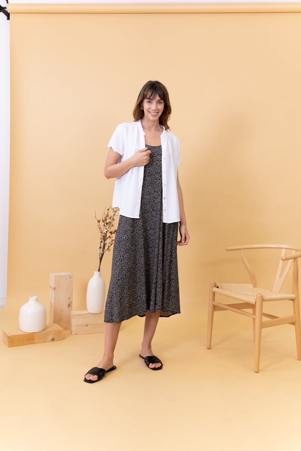 MODELO DE FRENTE CON VESTIDO ESTAMPADO NEGRO Y CAMISA BLANCA
