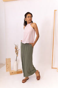 MUJER CON TOP ROSA Y FALDA VERDE