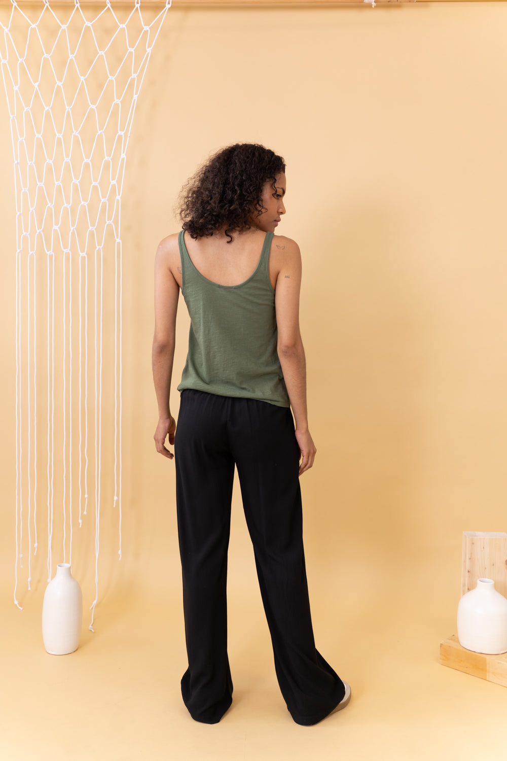 MODELO CON PANTALÓN NEGRO DE ESPALDA