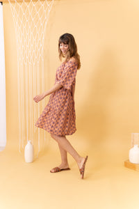 MUJER DE LADO CON VESTIDO ESTAMPADO CORAL