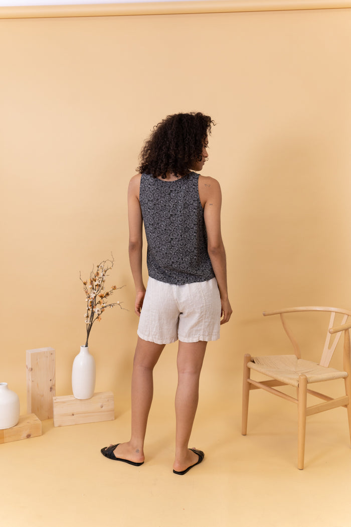 MUJER DE ESPALDAS CON TOP ESTAMPADO NEGRO