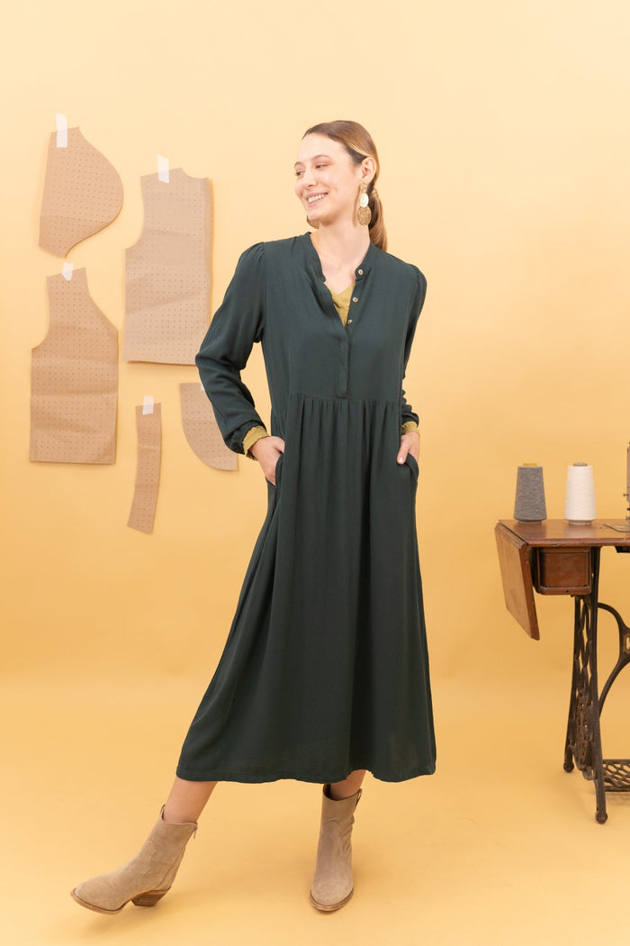 vista frontal de vestido midi de color verde con modelo estirando una pierna al lateral
